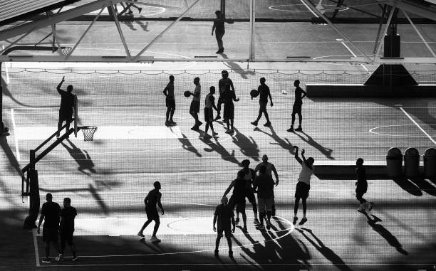 siluetas de jugadores de baloncesto al caer el sol, ciudad de nueva york. - baloncesto fotos fotografías e imágenes de stock