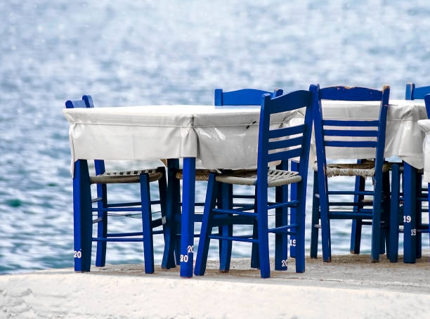 istock Tables and blue chairs by the seaside. Greece 1008271378