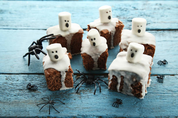 Halloween cookies with marshmallows and spiders on wooden table