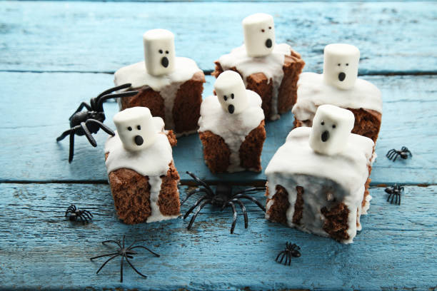 Halloween cookies with marshmallows and spiders on wooden table stock photo