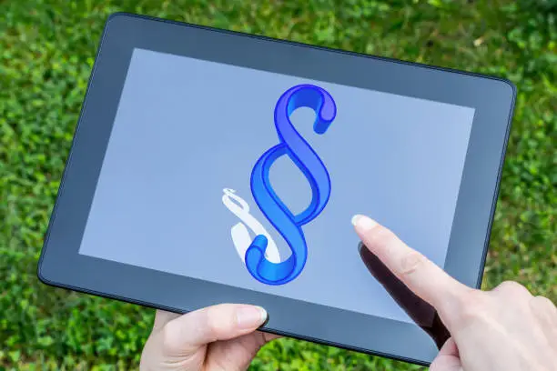 Photo of Finger points to a digital paragraph sign on a tablet