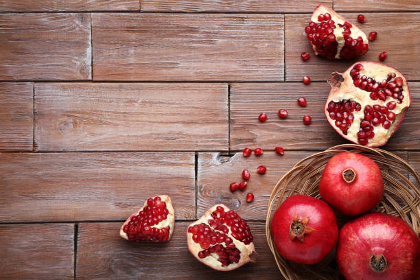 istock Ripe and juicy pomegranate on brown wooden table 1008288054