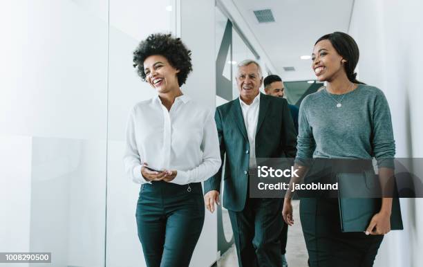 Team Of Corporate Professionals In Office Corridor Stock Photo - Download Image Now - Business Person, Walking, Office