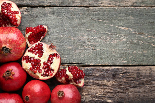 istock Ripe and juicy pomegranate on grey wooden table 1008290666