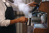 Barista making a cup of coffee in machine