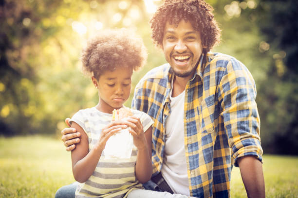 istock Father and daughter sitting on grass. 1008291132