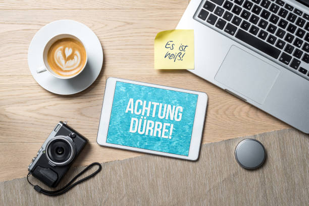 istock Attention drought written in german on tablet in office desk as flat lay 1008293534