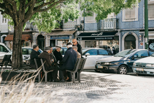 Older men locals sit on a bench and communicate in Lisbon in Portugal stock photo