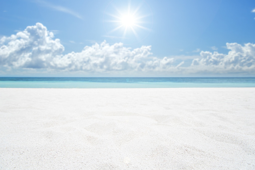 Straw hat and sunglasses on the beach sand