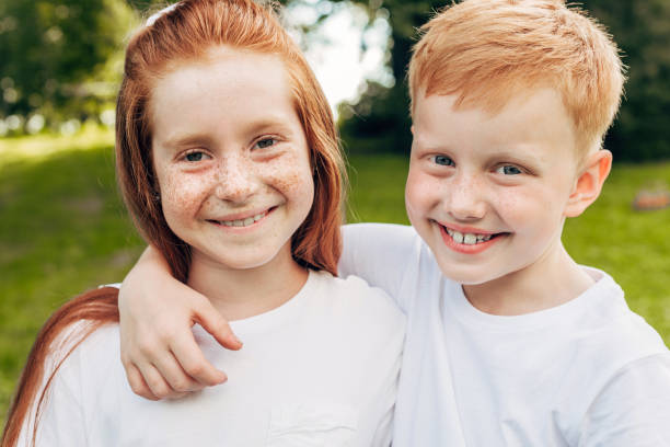 istock beautiful happy redhead siblings embracing and smiling at camera in park 1008304534