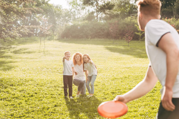 istock happy redhead family playing with flying disk at park 1008304782