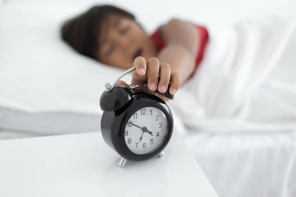 istock Little boy stopping alarm clock in morning 1008308712