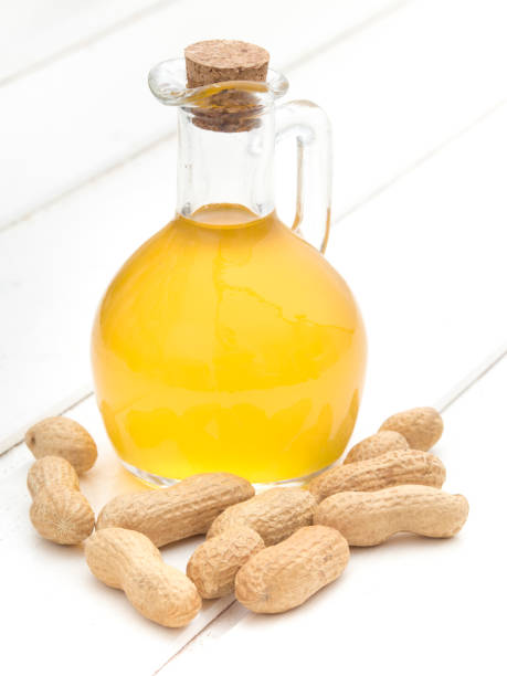 istock Peanut oil on white wooden background 1008312598
