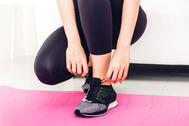 istock Woman tying up shoelaces on running shoe 1008320962