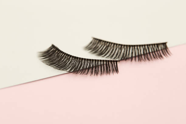 istock Eyelashes on pink and green paper backgorund 1008345940