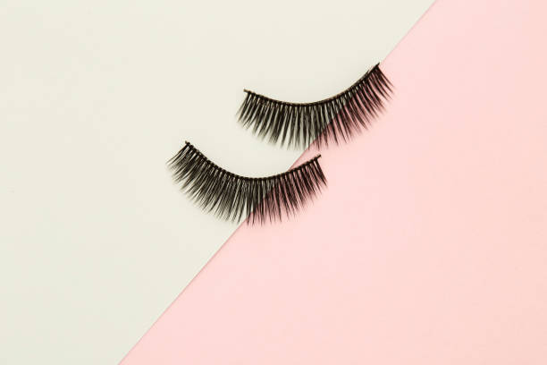 istock Eyelashes on pink and green paper backgorund 1008345978