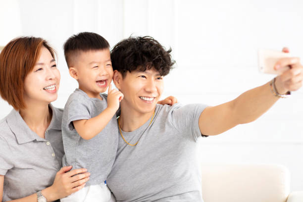 istock happy asian family  taking selfie on sofa 1008349292