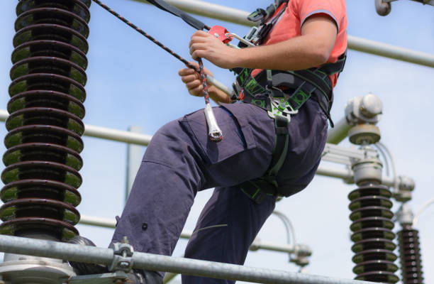 istock Electrician with protective workwear, hardhat and safety harness at work 1008357702