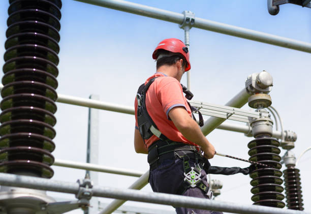 istock Electrician with protective workwear, hardhat and safety harness at work 1008357810