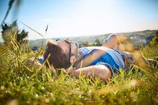 Man lying in grass on hiking trip in the mountains