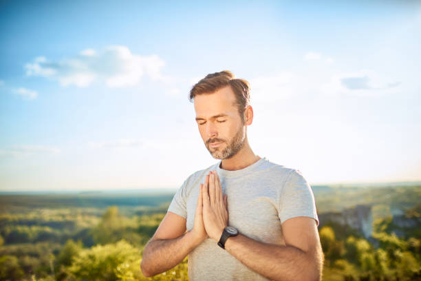 istock Serenity concept. Man praying or meditating outdoors 1008363762