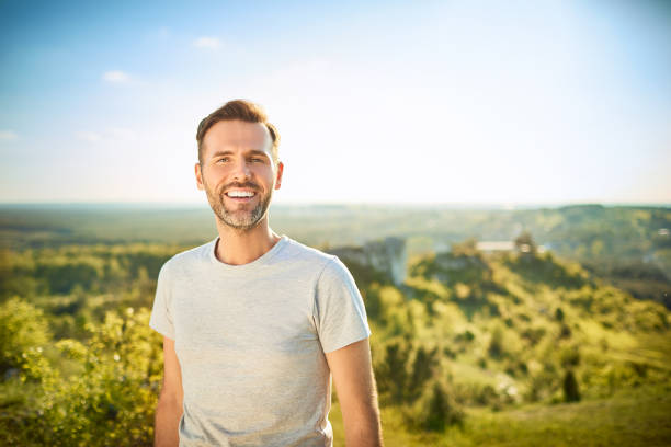 retrato de homem sorrindo para a câmera enquanto em viagem nas montanhas - entrepreneur lifestyles nature environment - fotografias e filmes do acervo