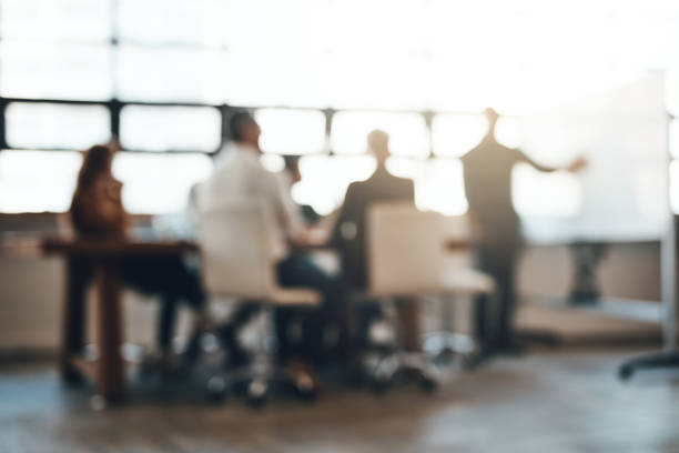 Making success happen Shot of businesspeople having a meeting in an office defocused woman stock pictures, royalty-free photos & images