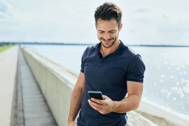 Happy man texting on his phone outdoors