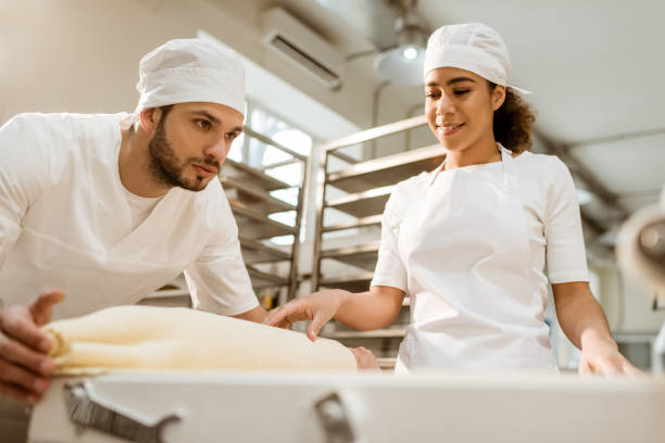 istock young bakers working with industrial dough roller at baking manufacture 1008378824