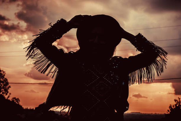istock Silhouette of boho woman raising hands 1008378832