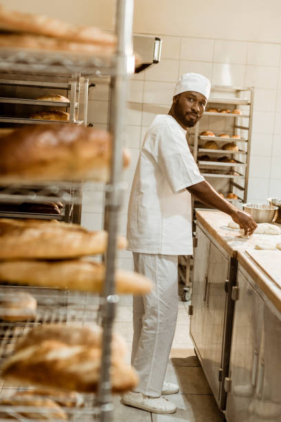 istock african american baker preparing raw dough at workplace on baking manufacture 1008378906