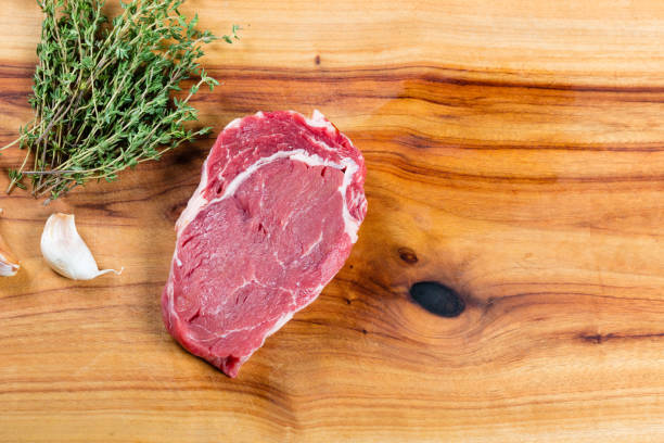raw beef scotch fillet steak on chopping board - scotch steak imagens e fotografias de stock
