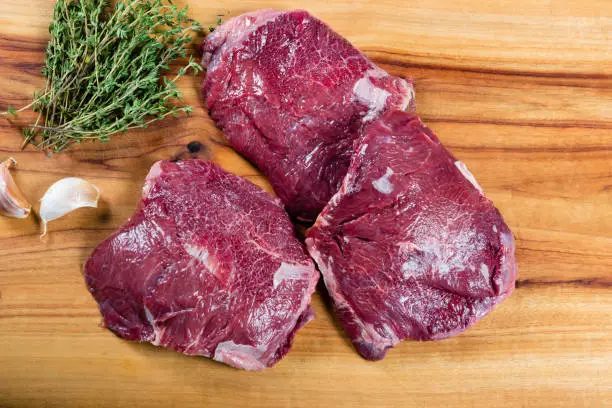 Photo of Raw beef cheeks on chopping board