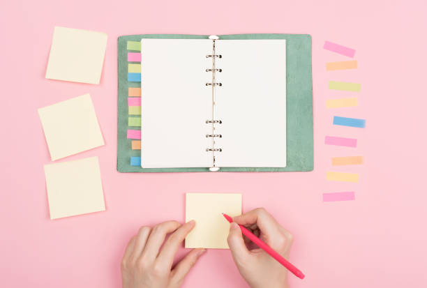 istock girl's hand writing in sticky note 1008383266