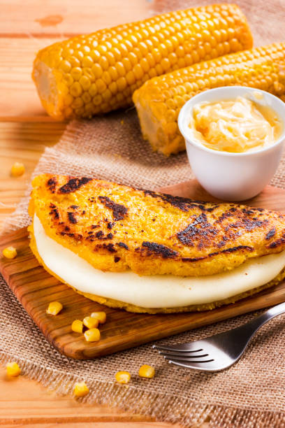 Wooden table with several ingredients for the preparation of Cachapas with cheese, corn, butter, ground corn and white cheese, Venezuelan Cuisine stock photo