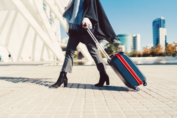 Businesswoman with suitcase hurrying for the flight Young woman just arriving in Spain and pulling a suitcase wheeled luggage stock pictures, royalty-free photos & images