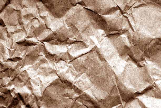 istock Old paper with wrinckles in brown tone. 1008393192