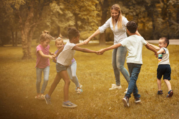 istock Group of children with teacher playing at nature. 1008405018