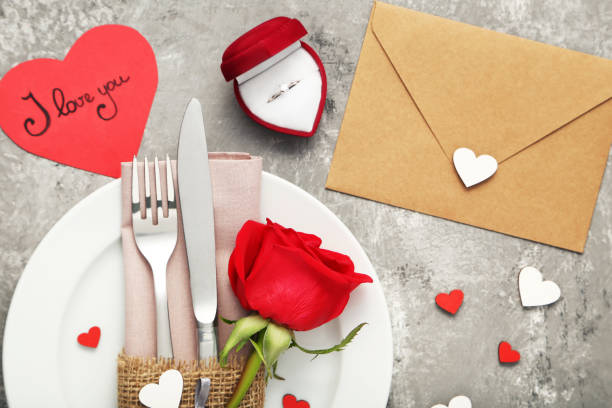 istock Kitchen cutlery with red rose in white plate and silver ring 1008408642
