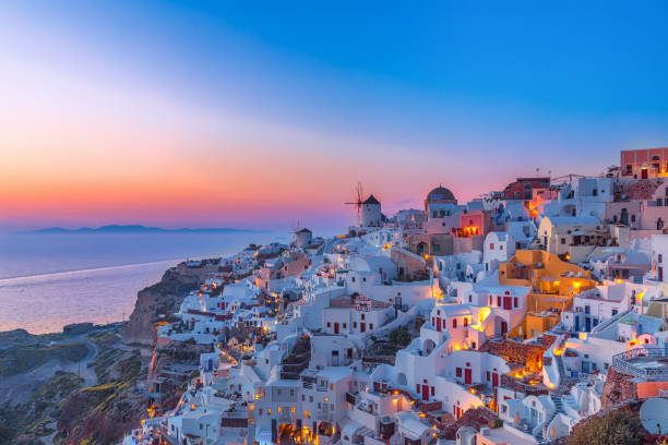 Stunning view of Oia on Santorini at dusk Stunning view of the village Oia on Santorini island at dusk with colorful twilight and white houses, windmill on the cliff, Greece. santorin stock pictures, royalty-free photos & images