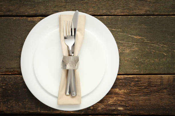 istock Fork and knife with napkin on white plate 1008408998