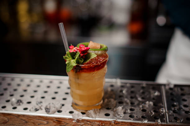 istock Orange cocktail decorated with red flower with green leaves, lime and rafinated sugar 1008409204