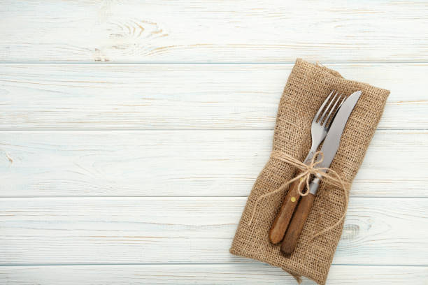 istock Fork and knife with sackcloth on wooden table 1008409208