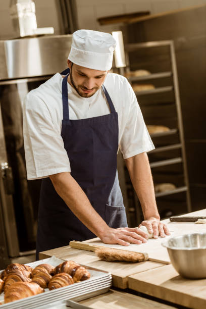 istock baker kneading dough for pastry on baking manufacture 1008409368