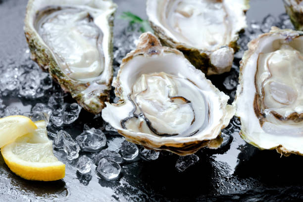 新鮮なカキ氷とレモン添え - prepared oysters ストックフォトと画像