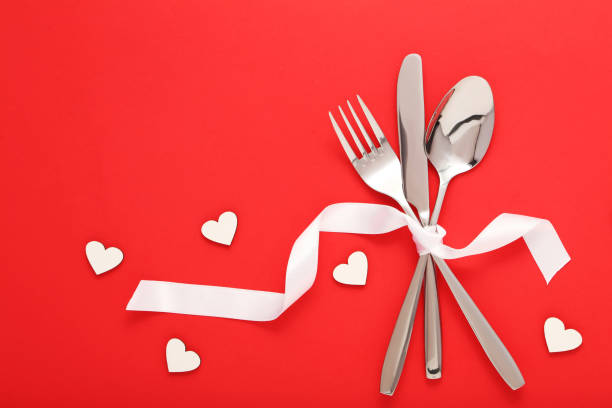 istock Kitchen cutlery with small hearts on red background 1008411760