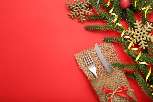 istock Kitchen cutlery with sackcloth and christmas decorations on red background 1008411920