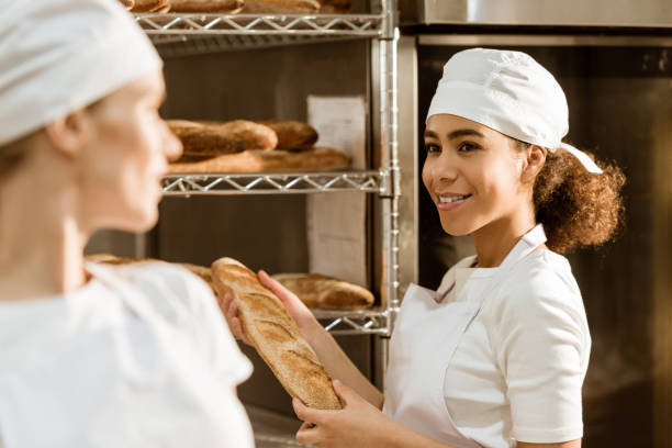 istock happy young female bakers working at baking manufacture 1008412782