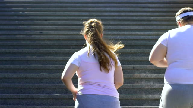 Couple with extra weight running upstairs to lose weight, outdoor cardio workout