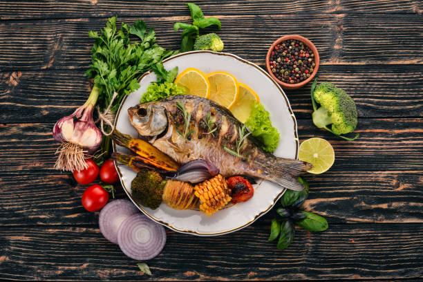 Baked fish carp. On a wooden background. Top view. Copy space.
